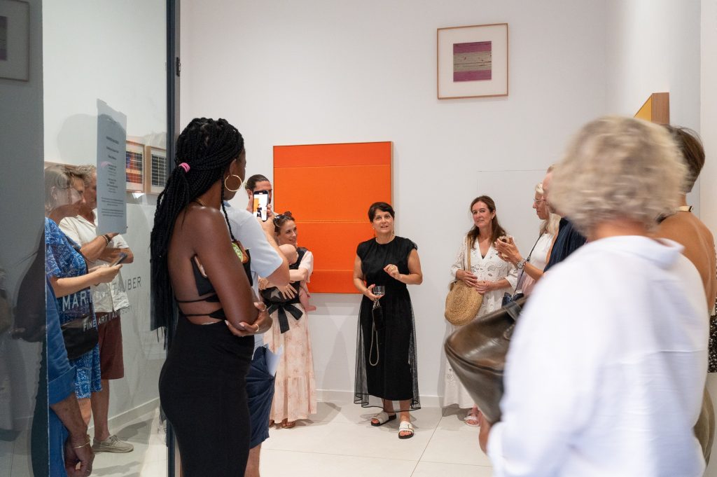 A guided gallery visit, a small group in front of the work